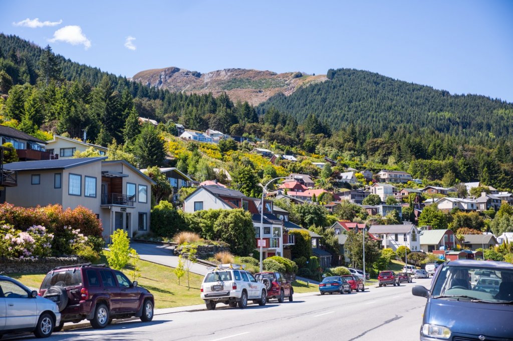 Straat in een stad van Nieuw-Zeeland met auto's en huizen.
