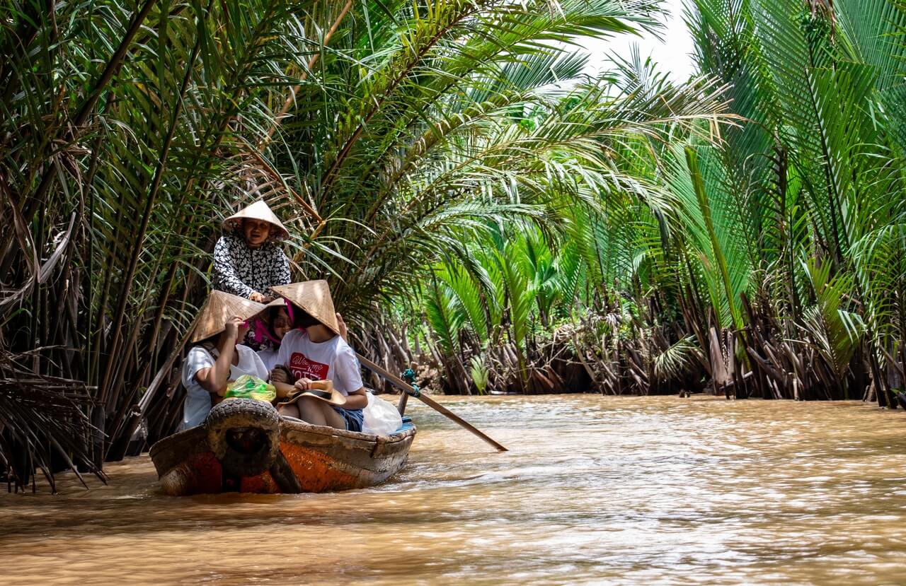 Een bootje op de rivier in de jungle met hierop vier Vietnamese vrouwen.